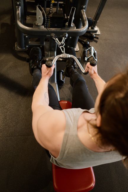 A woman using a seated cable row machine to build upper back pulling strength.